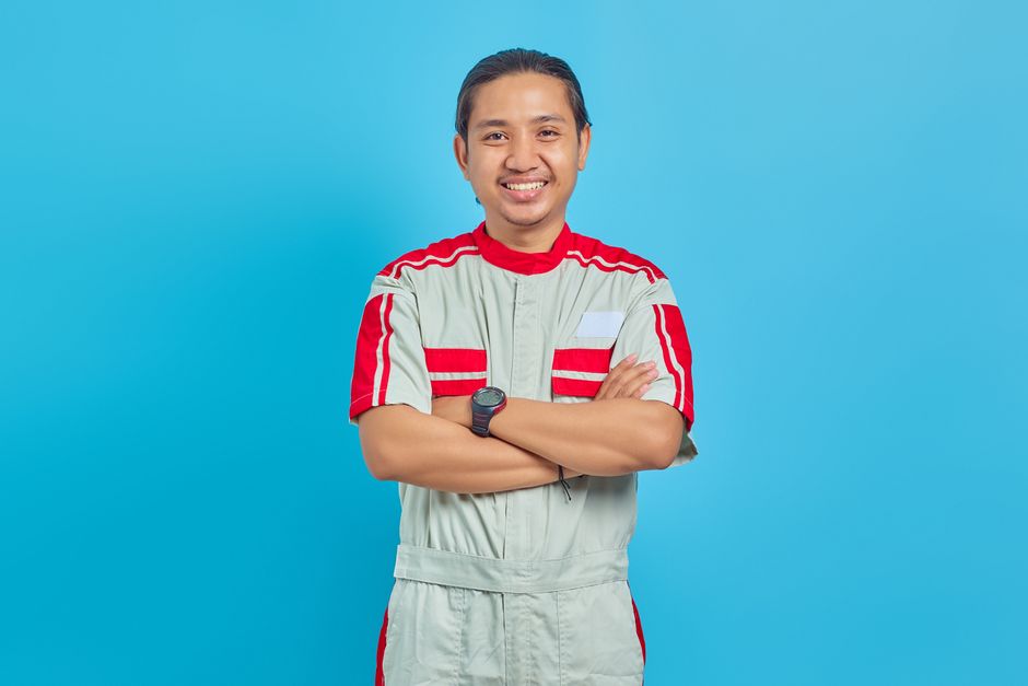 Friendly HVAC repairman standing proudly